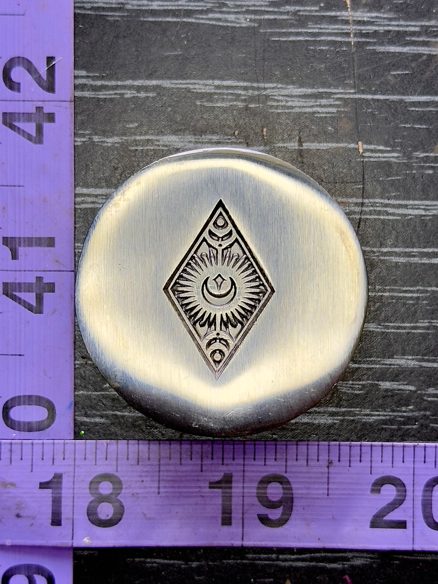 Radiating moon and star in a diamond shape steel impression die